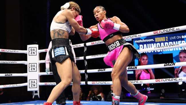 Alycia Baumgardner in a bright pink outfit, throwing a punch at her opponent