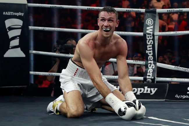 Callum Smith on his knees and crying out in celebration after winning a fight
