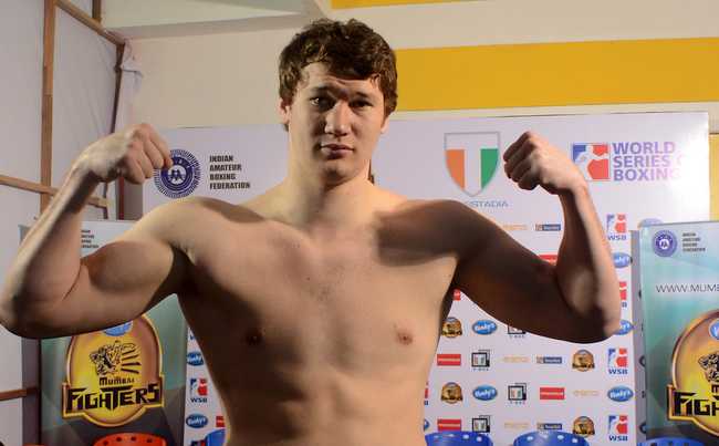 A large young man standing in a gym doing a muscle pose