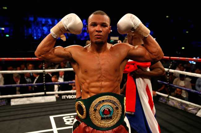 Chris Eubank Junior doing a muscle pose in the ring, wearing a belt