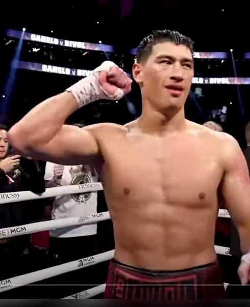 Dimitry Bivol raising his hand in victory after a fight